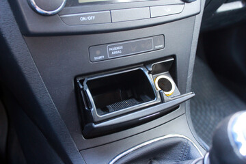 Open ashtray and cigarette lighter in the car. Car interior.