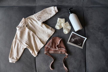 Concept maternity, pregnancy, childbirth. baby clothes on a bed.