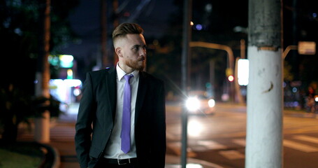 Pensive worried business man walking at night in city