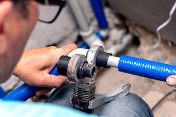 Work on the installation of heating or plumbing. The master connects plastic pipes with a soldering...