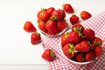 Fresh ripe strawberries in a plate on a white wooden background.Vegetarian organic berry.Healthy food.Vitamins.Copy space.Space for text