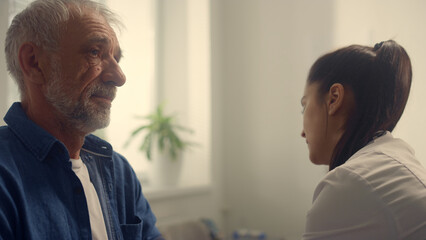 Obraz premium Woman cardiologist checkup blood pressure pensioner using tonometer closeup.