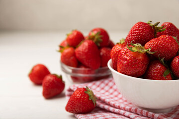 Fresh ripe strawberries in a plate on a white wooden background.Vegetarian organic berry.Healthy food.Vitamins.Copy space.Space for text