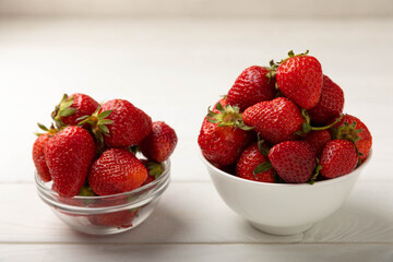 Fresh ripe strawberries in a plate on a white wooden background.Vegetarian organic berry.Healthy food.Vitamins.Copy space.Space for text