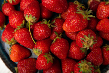Fresh ripe strawberries in a plate on a white wooden background.Vegetarian organic berry.Healthy food.Vitamins.Copy space.Space for text