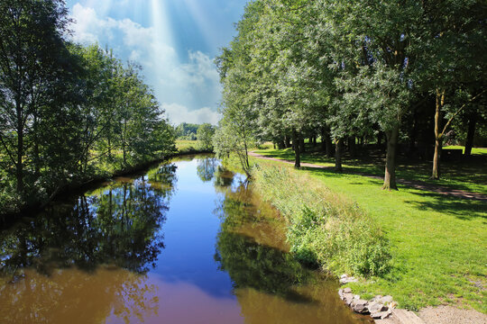 Beautiful idyllic lower rhine (Nierderrhein) landscape, river Niers, green forest park, morning sun rays - Wachtendonk, Germany