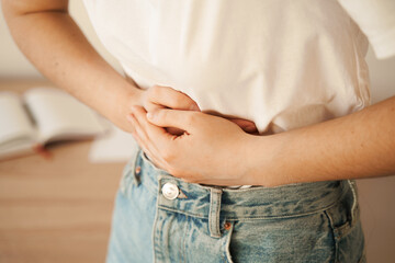 Stomach pain. Gastritis is an inflammation, irritation, or erosion of lining of stomach. Sick girl hold abdomen because it hurts. - obrazy, fototapety, plakaty