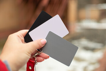 18 percent grey gray card, white and black card used for photography in girl's hand outdoors