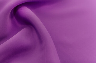 Background from a crumpled piece of purple fabric. Material silk with waves and folds
