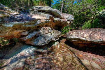 rocky path between masive sandstone boulders in a woodland forest