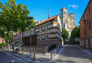 Cobbled street going over a canal near the Cathedral Basilica of Our Lady of Amiens in Picardy -...