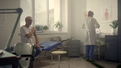 Doctor making vaccine injection elderly man in hospital. Immunization concept.