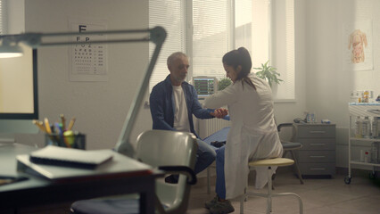 Fototapeta premium Physician checking pulse senior patient in hospital. Doctor testing heartbeat.