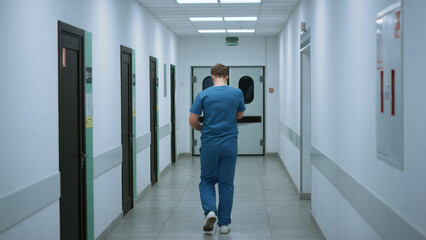 Two physicians hurrying help patients after conversation in clinic corridor.