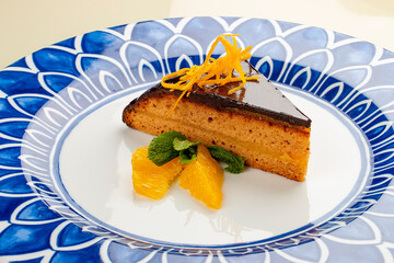 Orange, sponge cake under chocolate frosting. On a white background, isolated.