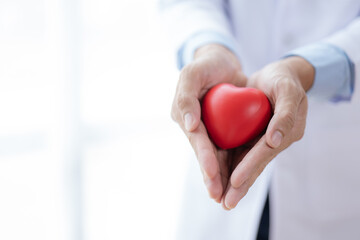 Close up of doctor holding a red heart. Medical health care and doctor staff service concept.