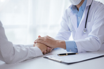 Fototapeta premium Close-up hands of doctor and patient in medical office.
