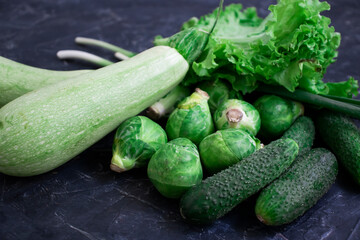 Green different vegetables on a dark background