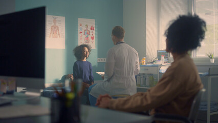 African mom waiting medical examination preteen daughter in pediatrician office.