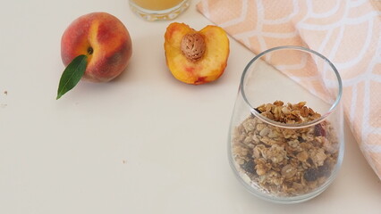 Homemade oatmeal granola with yogurt and peaches in glass for healthy breakfast. Cereal and fruit breakfast bowl with yogurt.