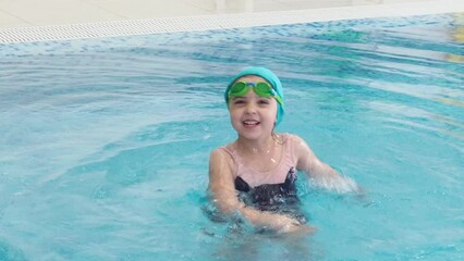 Little girl learning to swim with mother in big sport pool. Swimming school for small children. Healthy kid enjoying active lifestyle. Preschooler practicing with foam pad and noodle.