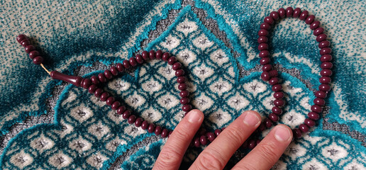 green prayer rug and prayer beads, Islam and prayer rug, worship materials in Islam,