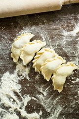 Top view of uncooked traditional Ukrainian dumplings with cherries. These varenyky are usually prepared in the summer