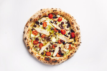 Top view of pizza topped with tomato, chicken, olives and mushrooms on a white background
