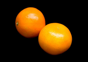 two tangerines lie on a black background