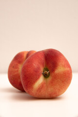 Donut peaches in front of a yellowish white background