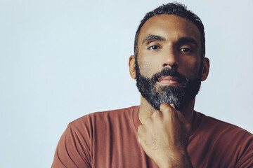 headshot portrait of a handsome bearded mid adult man looking at camera against gray background studio shot