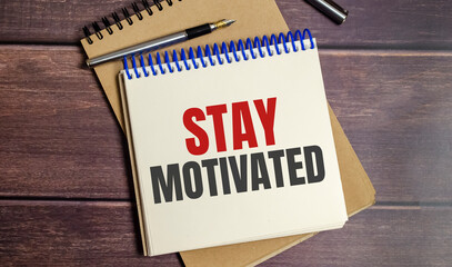 stay motivated words on notepad and wooden background
