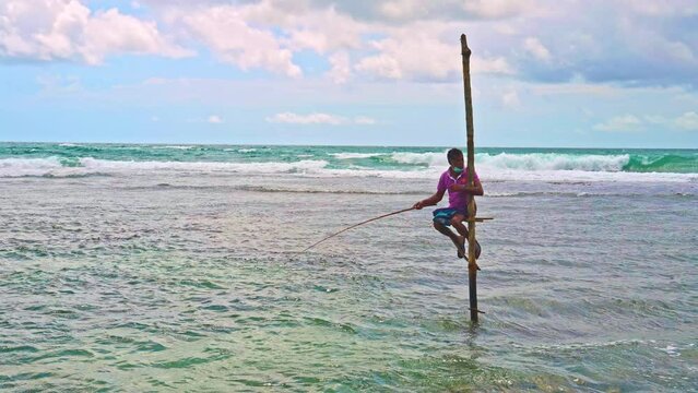 Sri Lankan stilt fisherman in slow motion near Galle in Sri Lanka