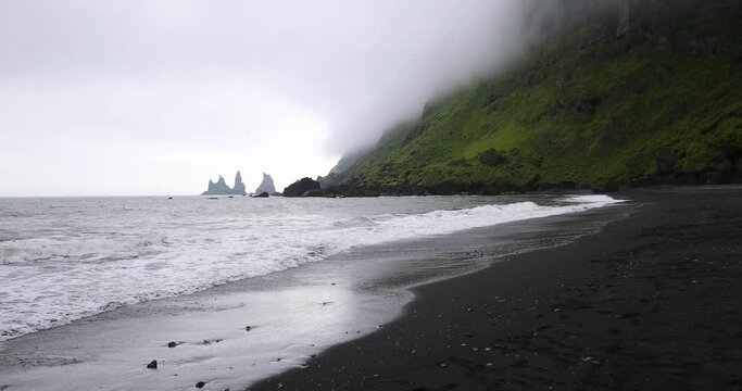 Mountains covered with fog - Three Atlantic Puffins circle the sea above the black sand beaches of Vik - Reynisdrangar sea, Iceland