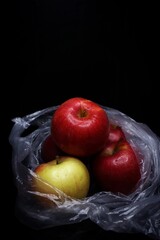 red and green apples in a plastic bag