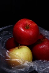 red and green apples in a plastic bag