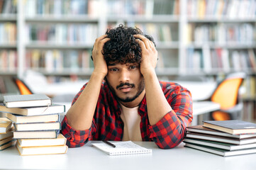 Tired exhausted indian or arabian guy, in casual clothes, a university student, or a high school...