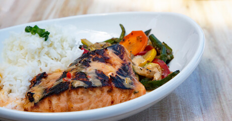 Delicious miso marinated salmon with rice and vegetables on white plate