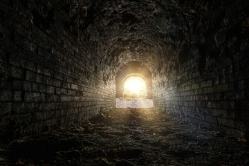 Historical underground red brick passage. Light at the end of tunnel