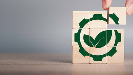Greenwashing concept. Green leaf and gear icon in wood cube Company investing more time and money...