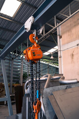 The construction crane in factory. chain hoist hanging on steel box