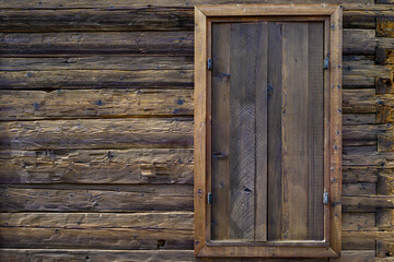 Wooden exterior of a rustic cabin built out of hand-hewn timber, as a textured background
