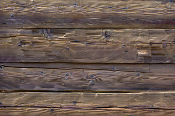 Fototapeta premium Wooden exterior of a rustic cabin built out of hand-hewn timber, as a textured background 