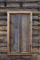 Wooden exterior of a rustic cabin built out of hand-hewn timber, as a textured background
