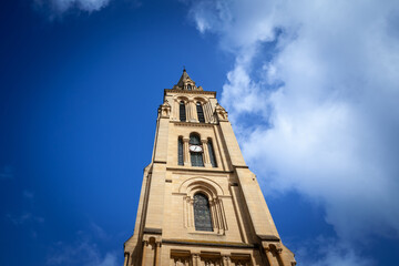 Fototapeta na wymiar Steeple tower of the Eglise Notre Dame de bergerac church, the main catholic church, neogothic, built in the 19th century in Bergerac, a city of Dordogne, in Perigord, in France.....