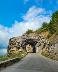 Road to the mountain. A road and rock tunnel in St Agnes, France