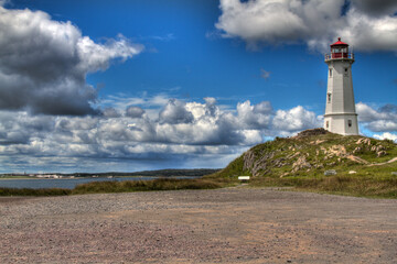 Fototapeta na wymiar historic lighthouse with dramatic clouds and road