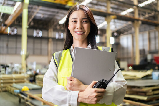 Portrait of Asian female industry worker working in factory warehouse. 