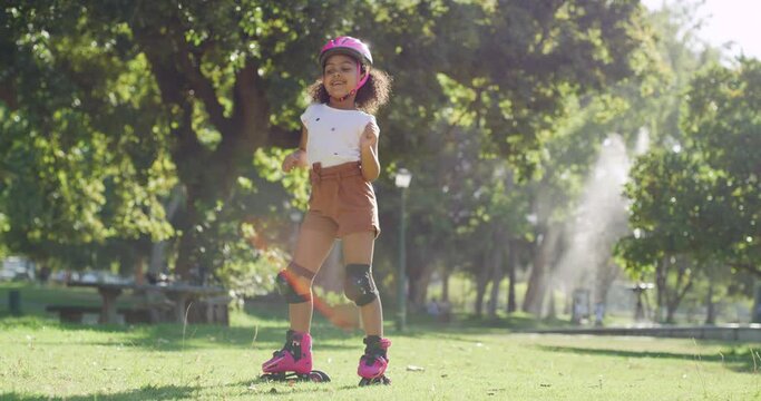 Cute and happy little girl dancing with roller skates in the park. Adorable mixed race child feeling carefree and enjoying her time outdoors. Summer fun just got a whole lot cute. The joy of skating