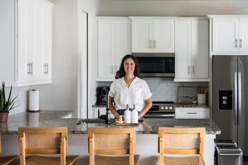 Woman smiling while standing in kitchen